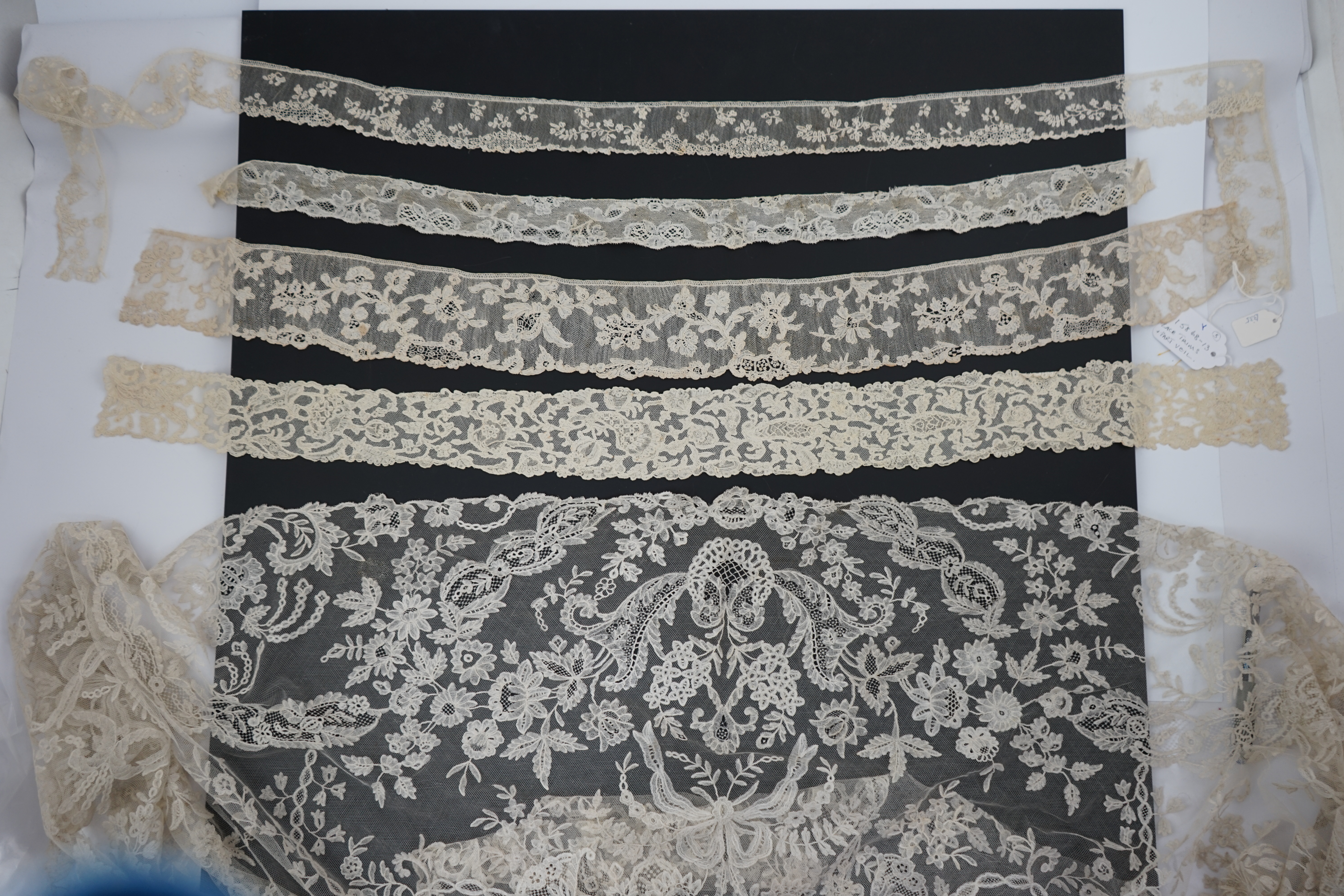 A large section of an ornate 19th century Brussels bobbin lace wedding veil, with two finished edges and one cut edge together with 18th century and later needle lace, an Argentan and an Alencon trimming, possibly an 18t